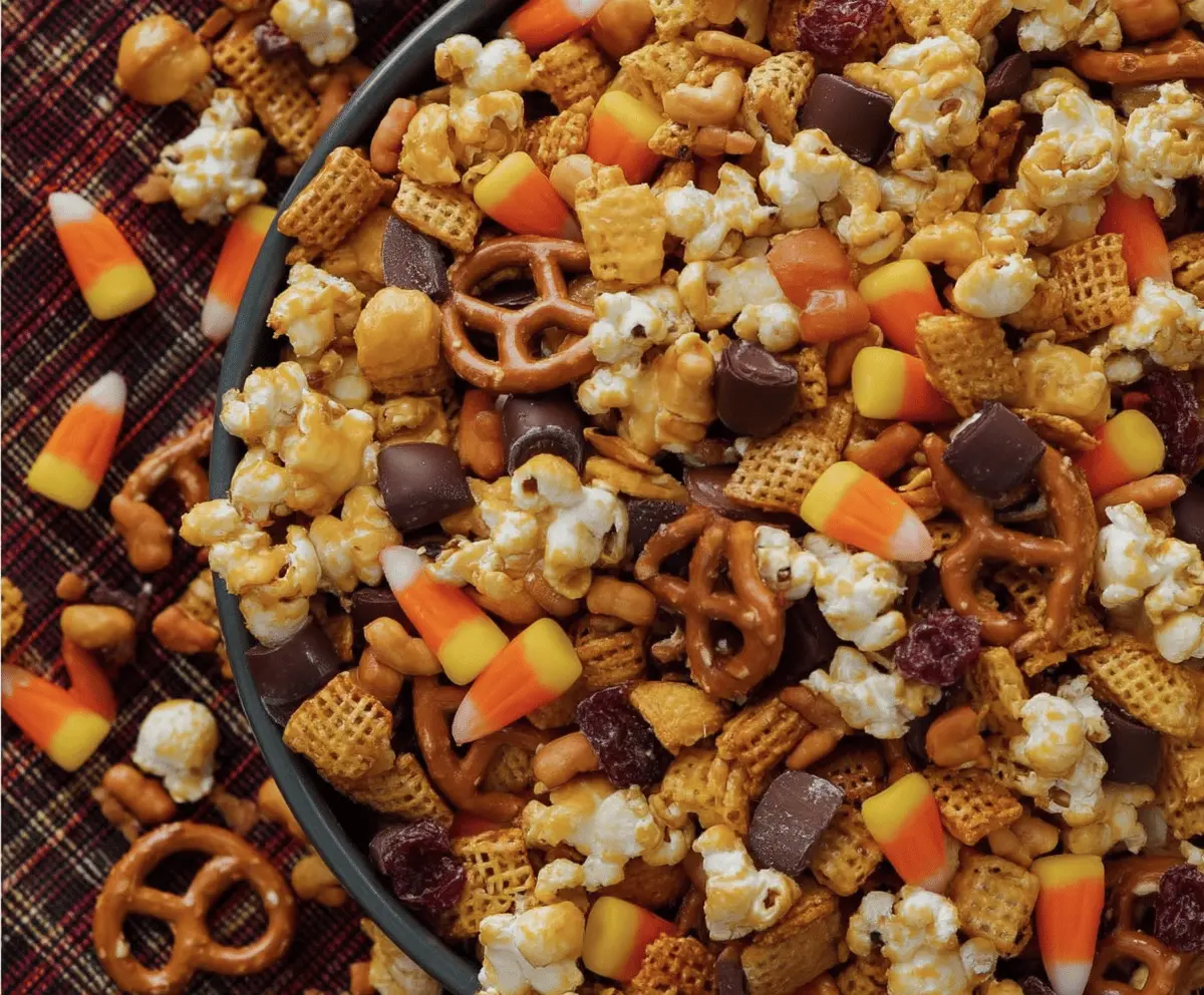Colorful fall snack mix with pretzels, nuts, dried fruits, and autumn-themed candies for a festive fall treat.