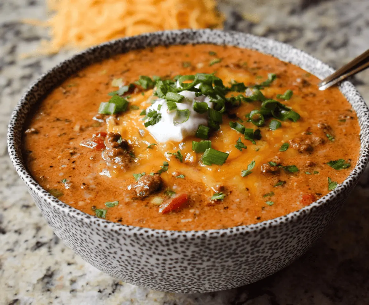 Delicious cheesy ground beef enchilada chili topped with melted cheese and fresh cilantro in a bowl