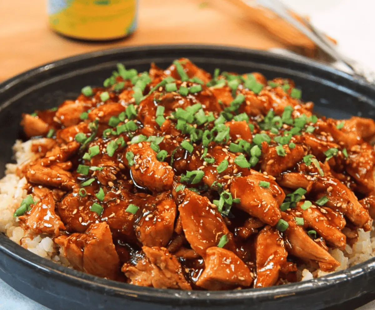 Delicious crock pot bourbon chicken served with rice and vegetables, perfect for a hearty dinner.