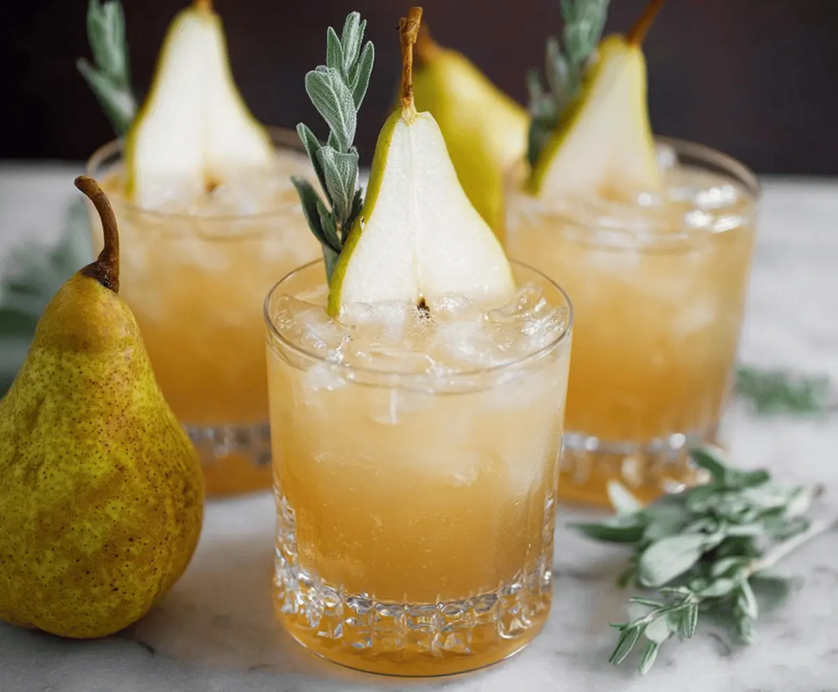 Refreshing Thanksgiving bourbon pear spritzers served in elegant glasses with fresh pear slices and garnishes, perfect for holiday celebrations