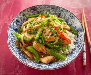 Delicious garlic chicken stir fry with bell peppers and broccoli served in a wok.