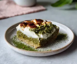 Delicious Matcha Tiramisu Baked Oats topped with fresh cream and cocoa powder, perfect for a healthy breakfast.