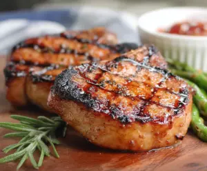 Juicy Southern Sweet Grilled Pork Chops served with a glaze on a barbecue plate.