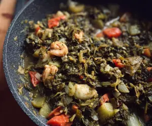 Delicious Callaloo and Saltfish served on a plate, showcasing fresh greens and seasoned fish.